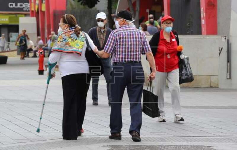 Personas paseando con mascarillas/EFE.